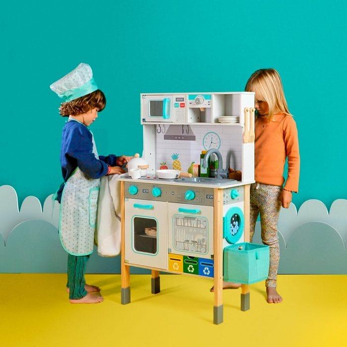 Niños jugando con la cocina infantil de madera de Aldi
