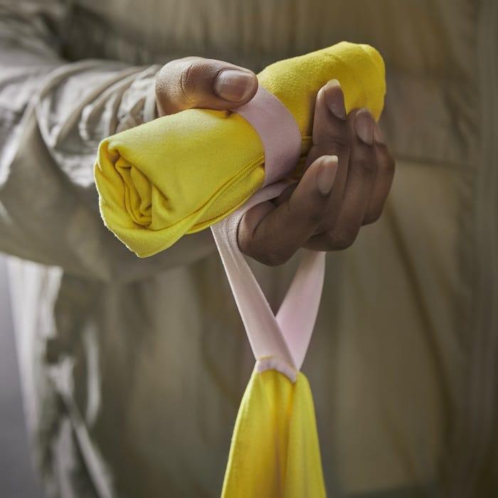 Mano sujetando una toalla amarilla con goma de Ikea