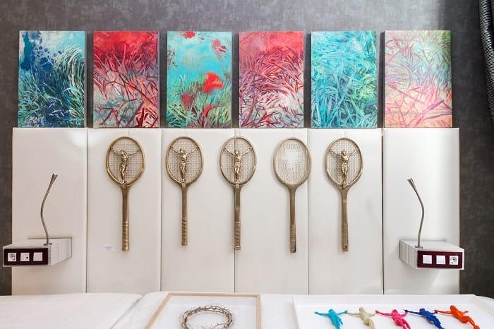 Raquetas con cristo en el interior y cuadros en HYBRID Art Fair