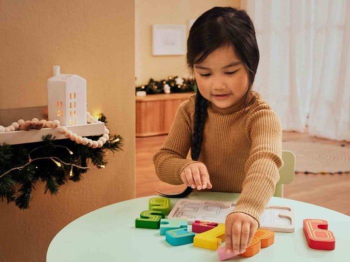 Niña jugando a un juego de madera educativa Montessori de Lidl