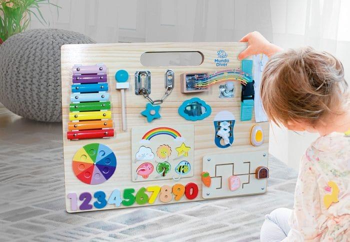 Niño jugando con un panel sensorial de Aldi hecho de madera