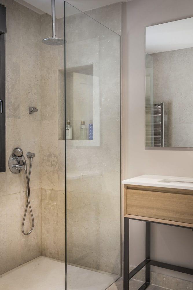 Cuarto de baño con ducha y mueble de lavabo de madera