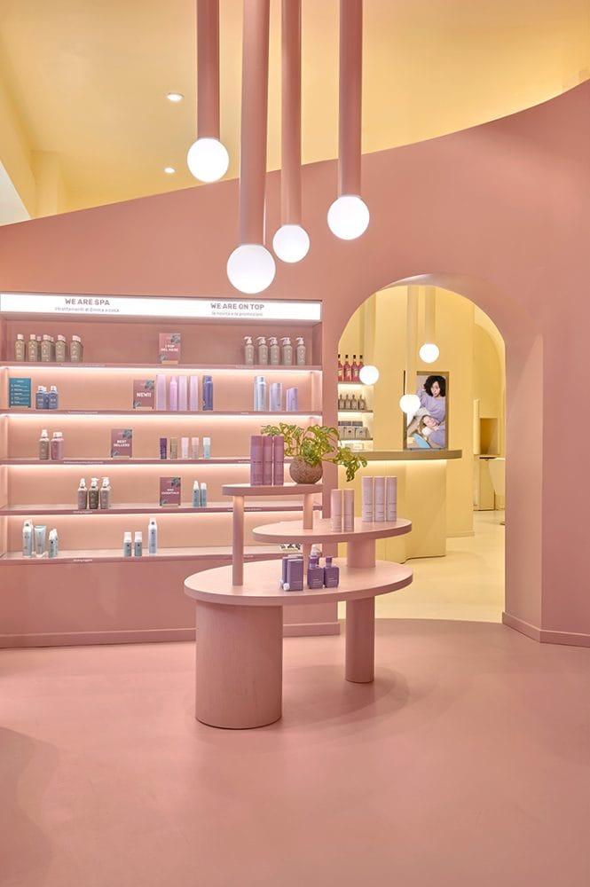 Diseño rosa de salón de belleza Emma con mesa y estantería con productos