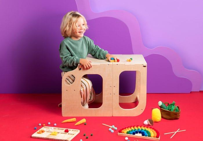 Niño jugando con la torre multifunción de madera de Aldi