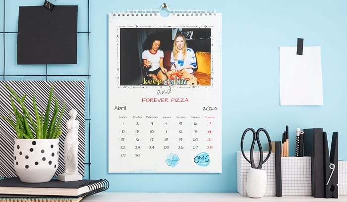 Escritorio con un calendario personalizado con fotos en la pared azul