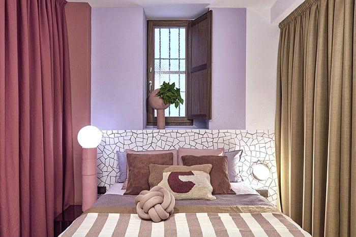 cama con cortinas lila y trancadis en cabecero