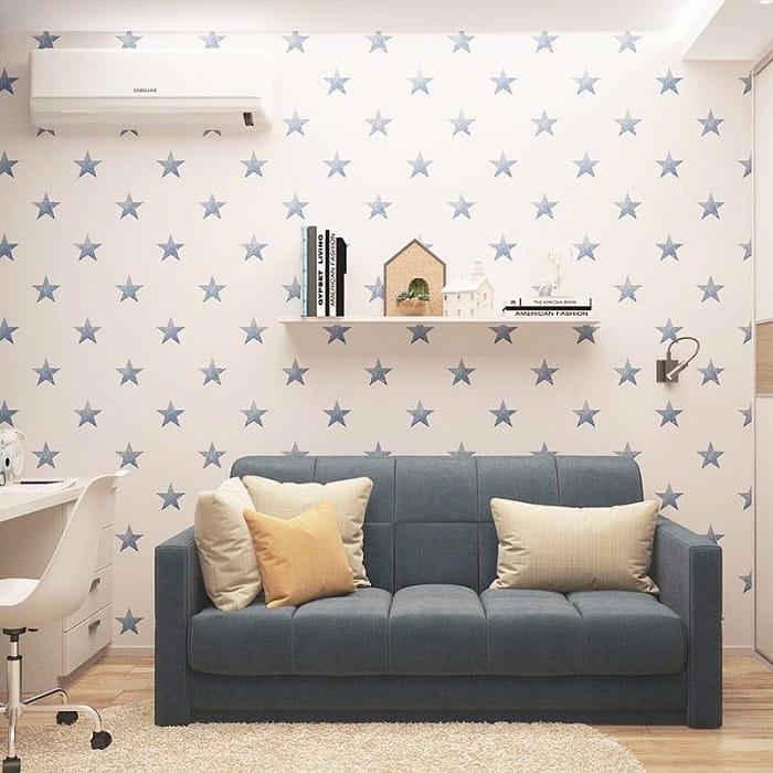 Habitación con un sofá y en la pared un vinilo infantil de estrellas