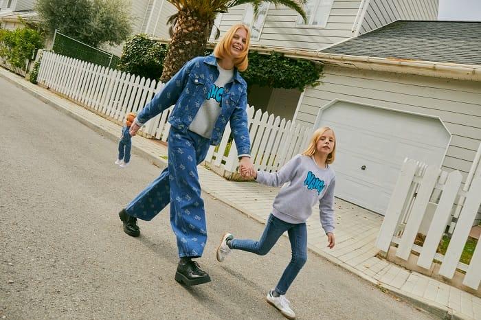 Madre e hija andando por la calle con una muñeca Nancy