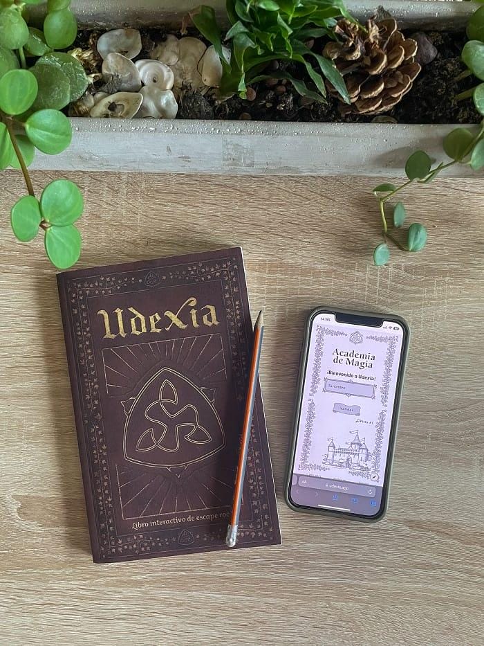 Libro Udexia de escape room con un móvil y lápiz al lado