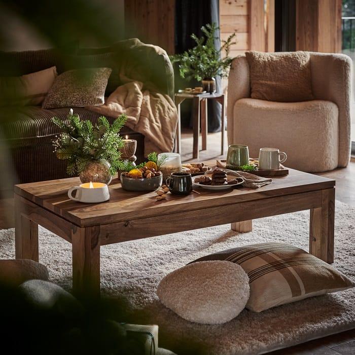 Salón con una mesa de centro de madera con decoración navideña estilo nórdico