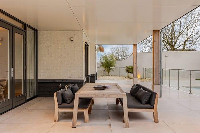 Exterior de la casa con mesa y sillas de la modelo Romee