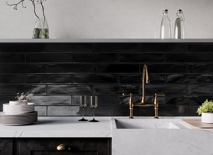 Cocina con encimera blanca y azulejos negros