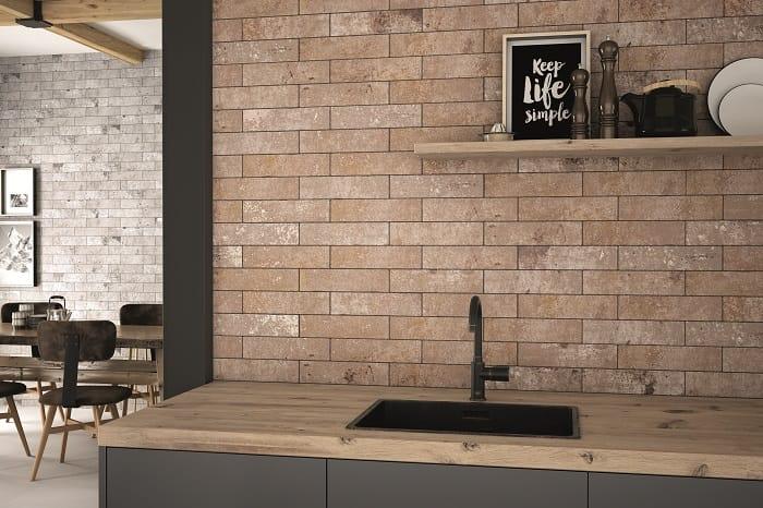 Encimera de madera en cocina negra con unos azulejos naturales