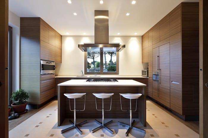 Interior de una cocina abierta con isla y con electrodomésticos integrados en los muebles de la cocina