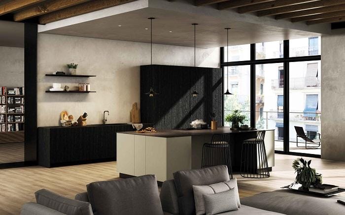 Diseño de una cocina en color negro con una isla blanca con taburetes y lámparas colgantes