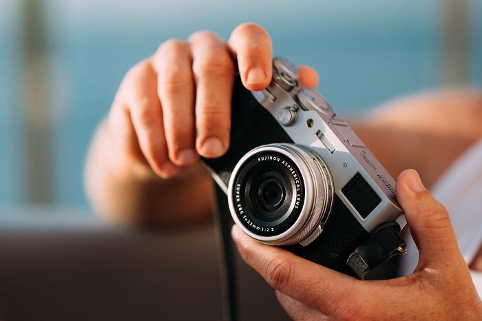 Manos sujetando una cámara Fujifilm fotográfica
