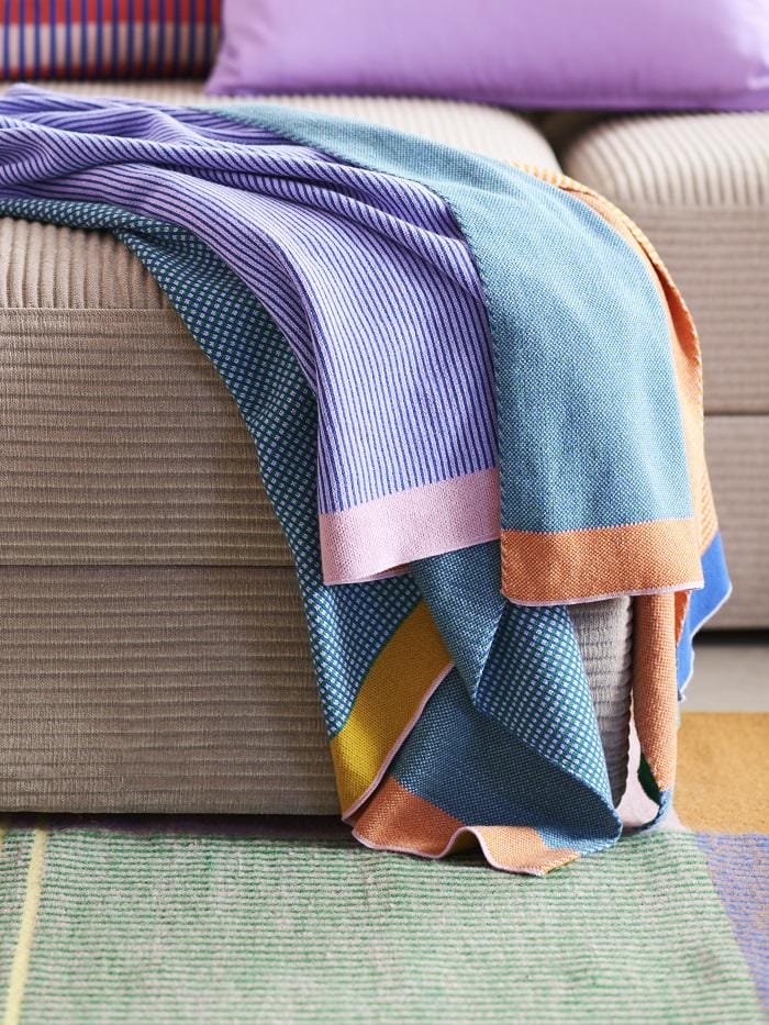Manta colorida sobre un sofá de Ikea