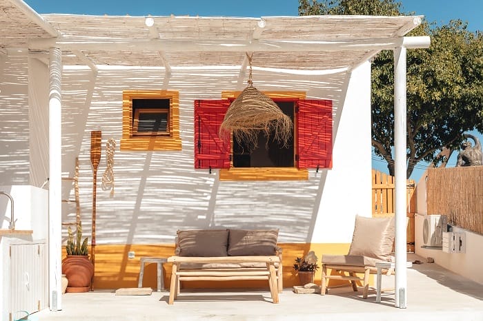 Zona exterior de una casa playera con mesa y sofás