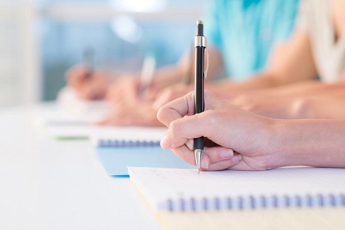 Varias manos escribiendo en sus cuadernos