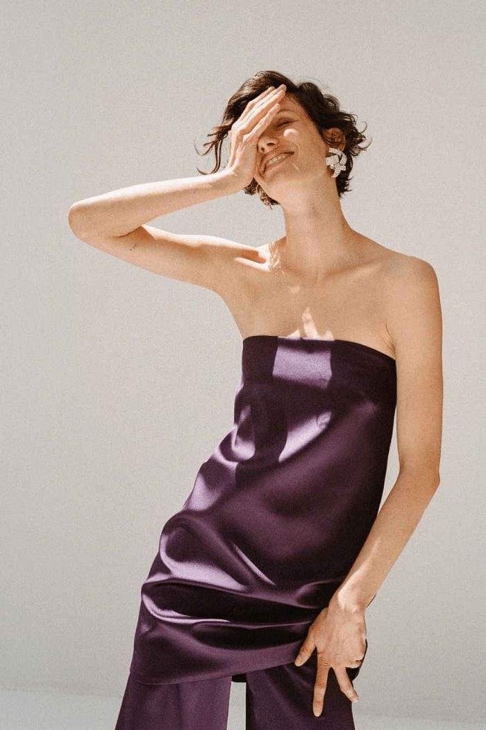 Modelo con un traje pantalón y palabra de honor morado