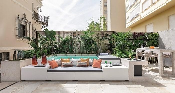 Terraza zona exterior en Casa Decor 2024 con piscina y grandes sofás con cojines