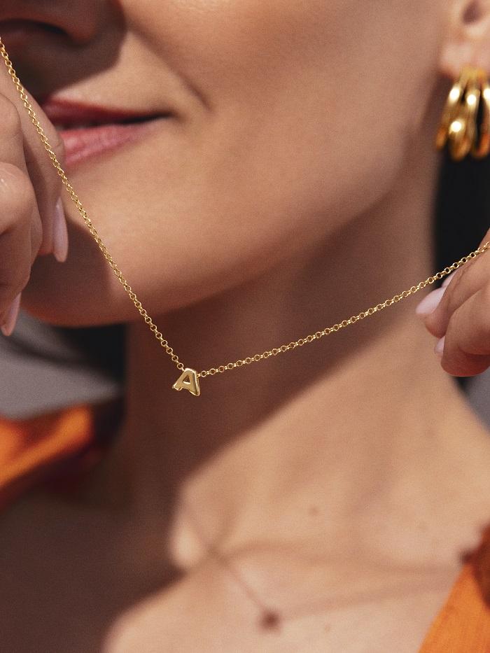 Mujer con un colgante con la letra A
