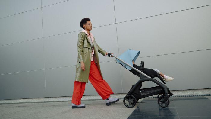 mujer paseando con carrito azul