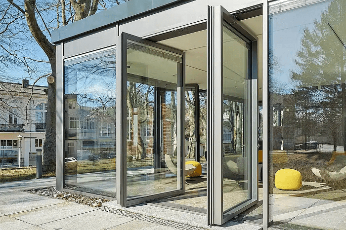 Puerta pivotante de acero abierta en un edificio de empresas