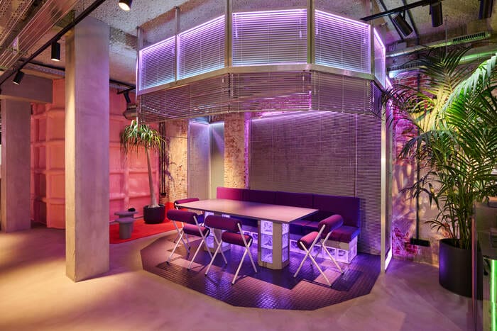mesa con luces morados con diseño futurista de la nueva tienda en Madrid Lynk & Co diseñado por Masquespacio
