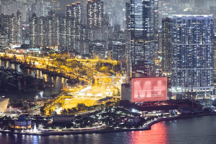 ciudad de noche con edificio y luces de coches fotografía hecho por Iwan Baan