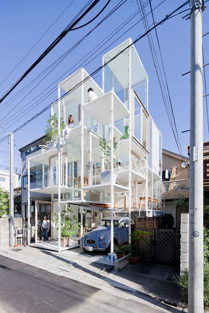 edificio arquitectura con coche azul y plantas fotografía hecho por Iwan Baan