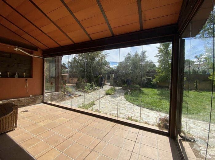 Interior de una casa con cortinas y cerramientos de cristal