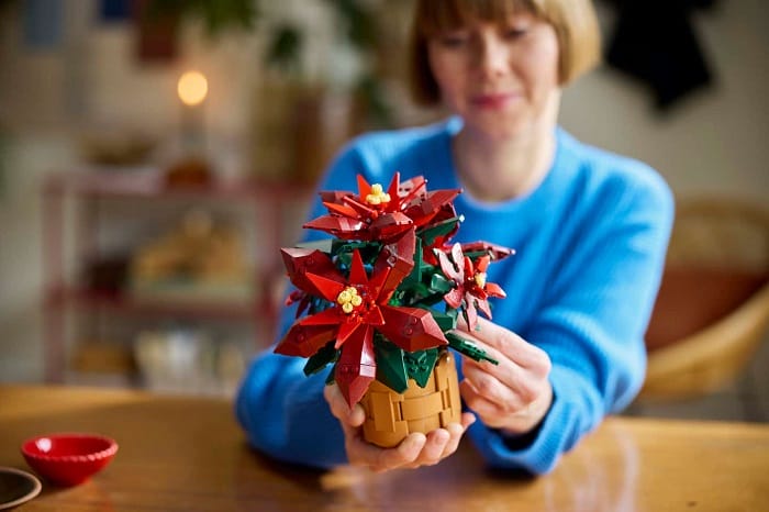 Mujer construyendo la flor de Pascua de LEGO