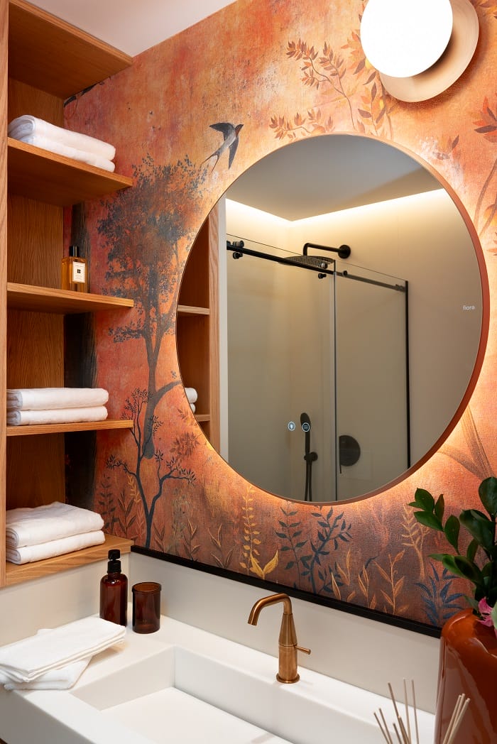 Zona de lavabo con un espejo redondo con luz de un cuarto de baño de diseño