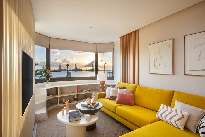 Diseño de un salón con un sofá amarillo y mueble curvo