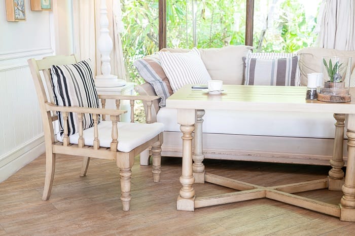 Salón con un sillón y silla de madera con cojines de rayas