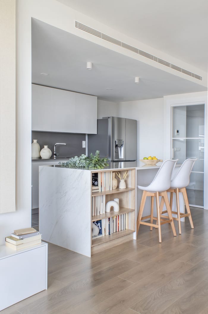 Pequeña zona de lectura en un rincón del salón, decorada con una butaca moderna, parte de la renovación de Anabel Soria