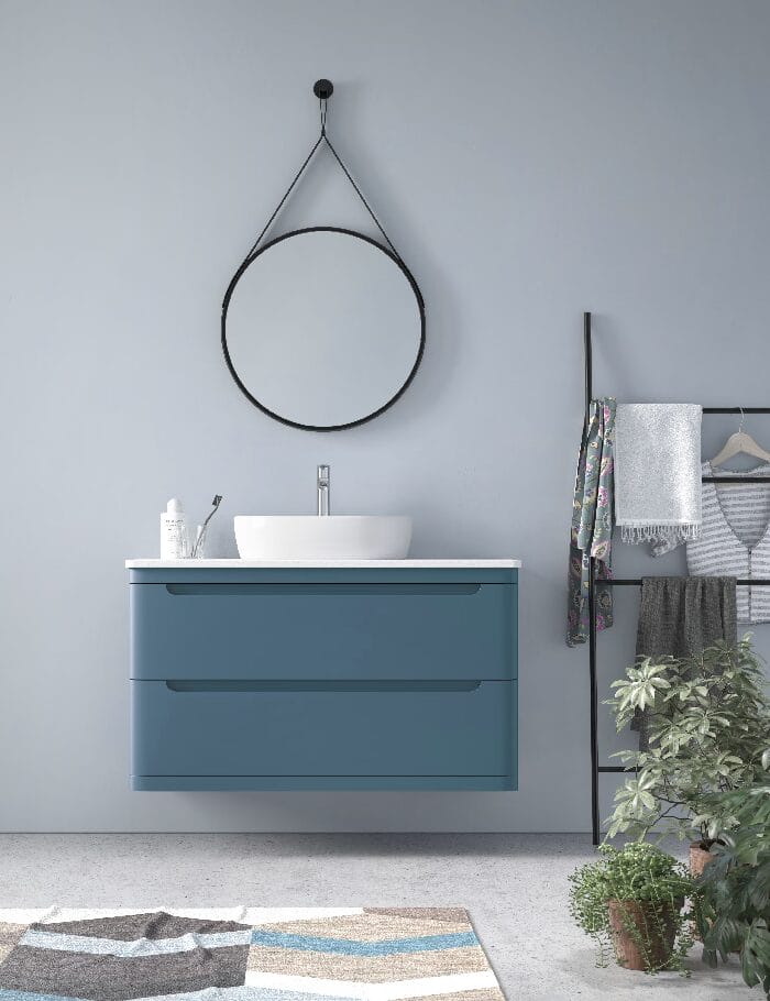 Mueble de baño de fondo reducido en color azul con dos cajones y espejo redondo colgado