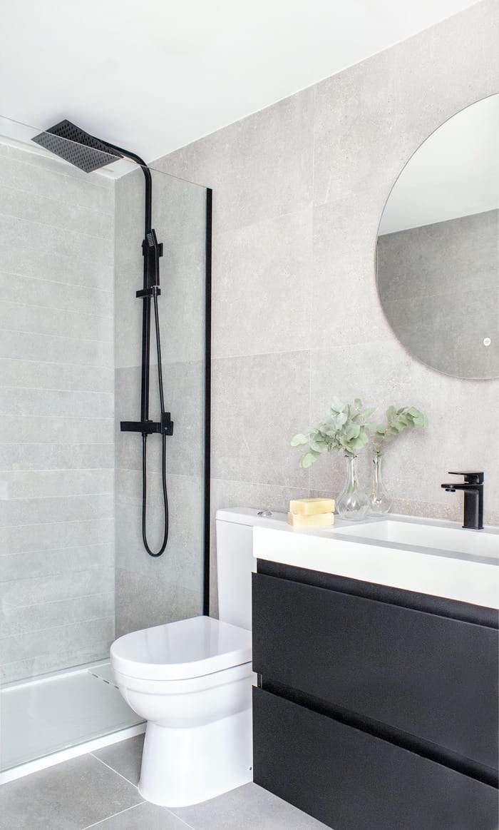 Baño de diseño elegante y funcional en un piso valenciano, renovado por Anabel Soria, con azulejos modernos y grifería minimalista