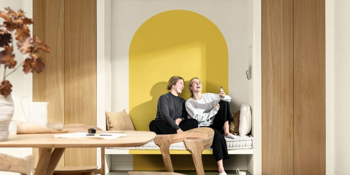 Paleta de colores en amarillo vibrante, blanco y marrón que ilumina el salón, creando un ambiente acogedor y lleno de personalidad