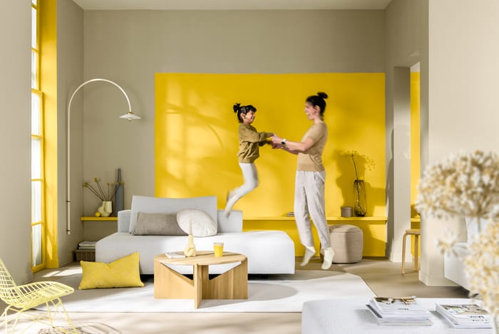 Paleta en tonos de marrón y blanco con acentos de amarillo, que transforma el salón en un espacio elegante y cálido, lleno de luz