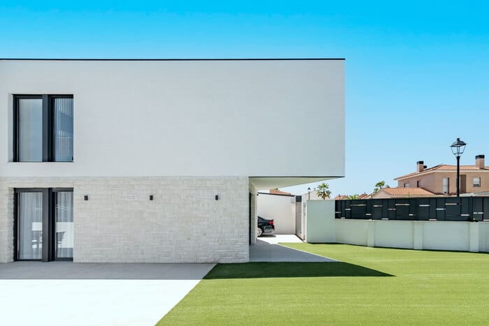 Fachada de vivienda con voladizo y revestimientos en tonos claros arquitectura moderna de ALEM Arquitectura