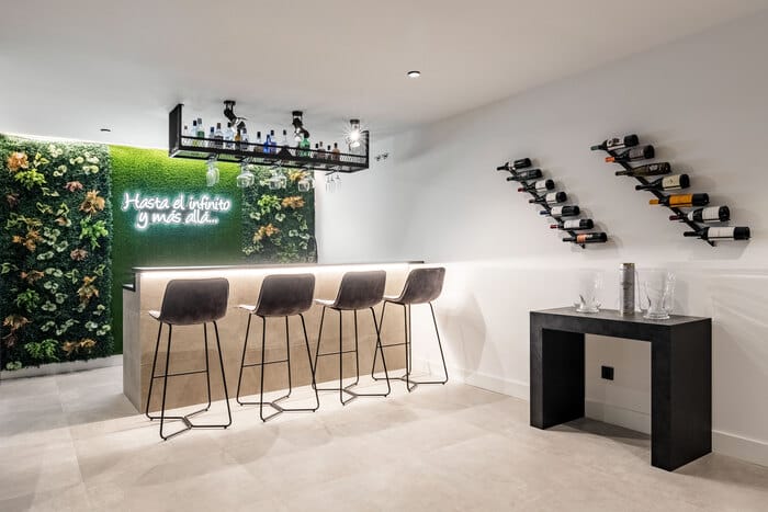 Vinoteca en sótano con jardín vertical y espacio para reuniones, diseño en vivienda de ALEM Arquitectura