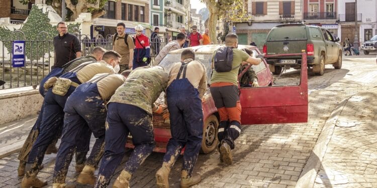 hombres empujando coche tras inundacion valencia