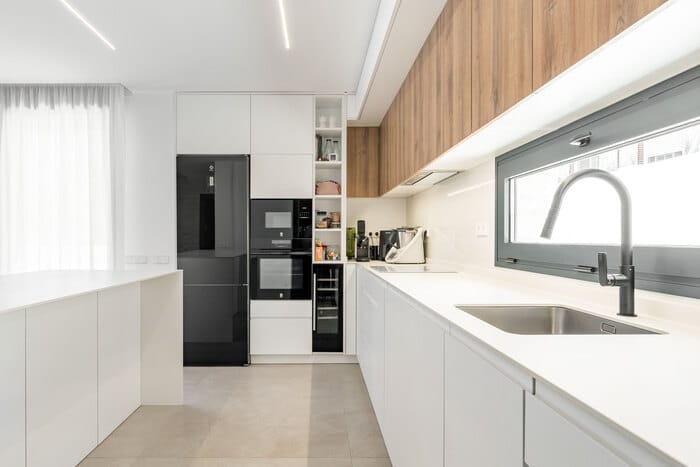 Cocina integrada con comedor y salón, diseño minimalista y elegante en vivienda de ALEM Arquitectura