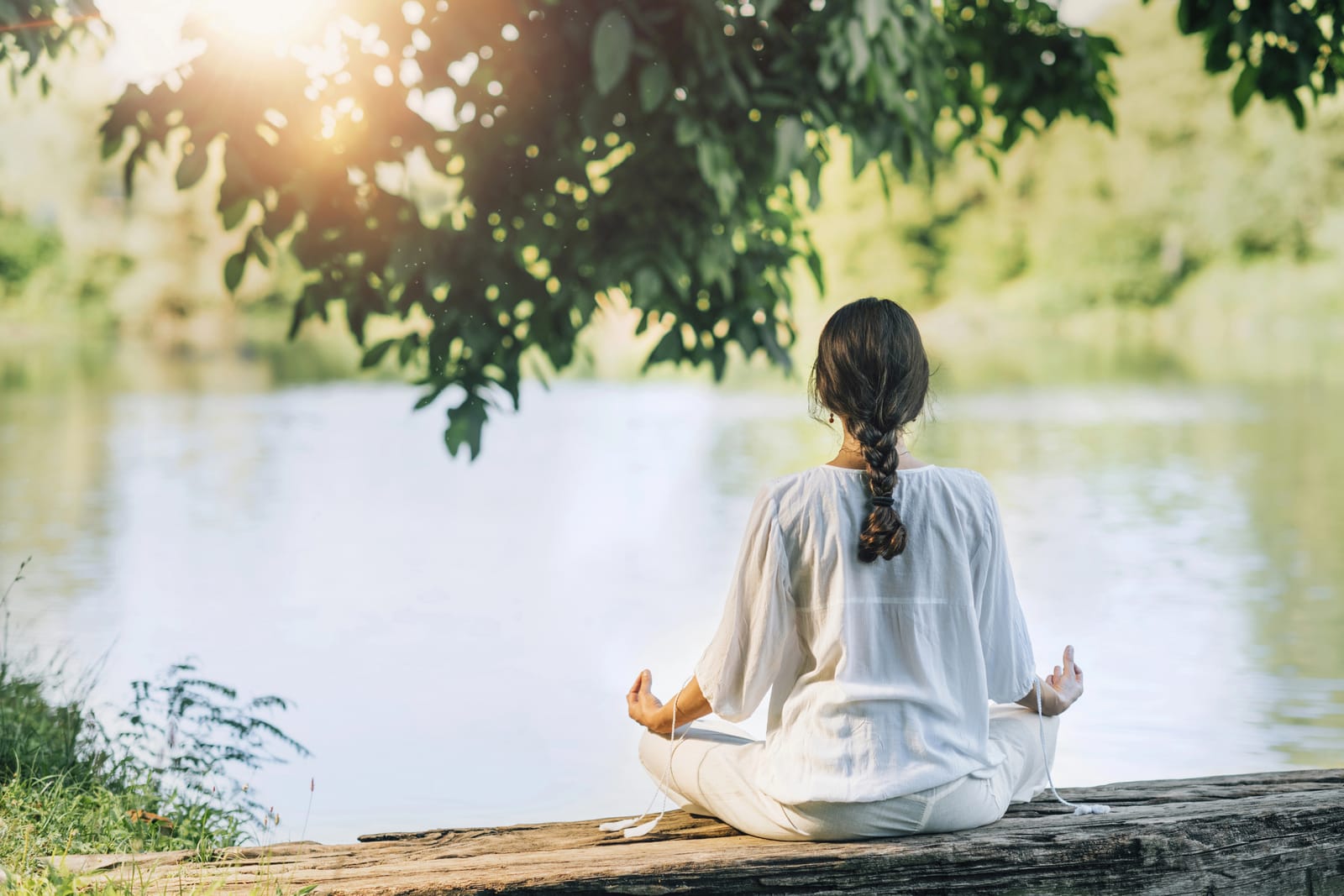 Mujer meditando frente a la laguna