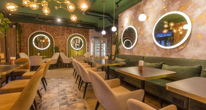 Muebles para restaurantes. Interior de un restaurante con decoración de sillas en beige y paredes beige y verde. Iluminación de techo de de diseño