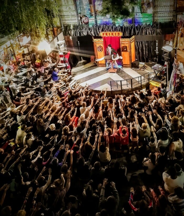 Público reunido en círculo disfrutando de una función al aire libre.