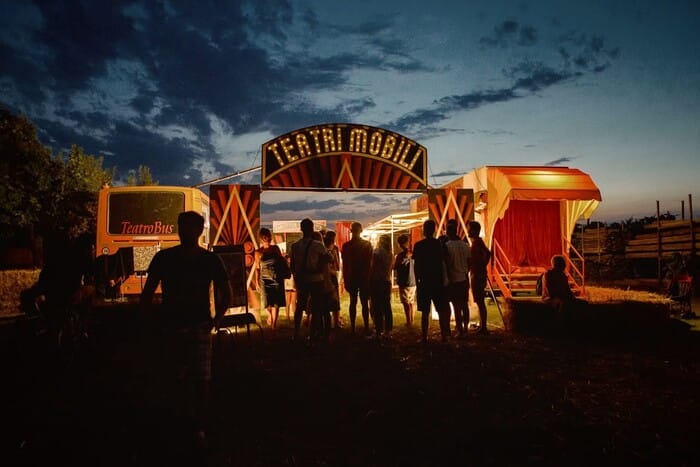 Escenario improvisado con telones coloridos y elementos tradicionales.