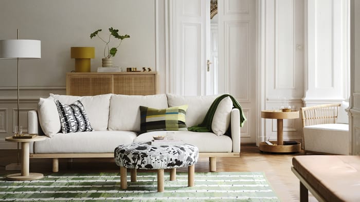 Sofá beige con estructura modular en salón amplio.